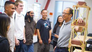 A professor talking with students in a lab.